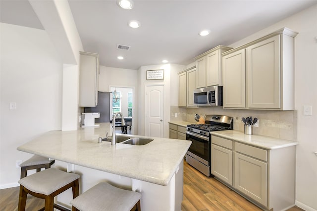 13823 Pointed Edge Ln, Cypress, TX 77429 - kitchen with appliances with stainless steel finishes, a sink, a peninsula, a breakfast bar, and backsplash