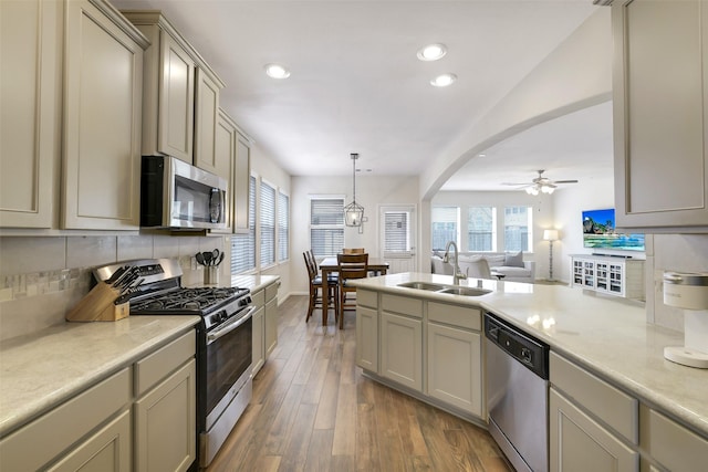 13823 Pointed Edge Ln, Cypress, TX 77429 - kitchen featuring stainless steel appliances, a sink, wood finished floors, decorative backsplash, and ceiling fan