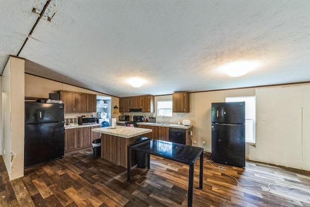 17968 County Road 426, Brazoria, TX 77422 - kitchen with black appliances, light countertops, dark wood-type flooring, a textured ceiling, and a kitchen island