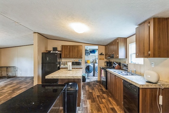 17968 County Road 426, Brazoria, TX 77422 - kitchen with black appliances, a sink, washing machine and dryer, dark wood-type flooring, and brown cabinetry