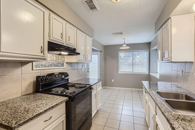 5607 Circlegate Dr, Spring, TX 77373 - kitchen with black range with electric cooktop, under cabinet range hood, backsplash, light tile patterned floors, and baseboards