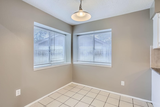 5607 Circlegate Dr, Spring, TX 77373 - unfurnished dining area with baseboards, light tile patterned floors, and a textured ceiling