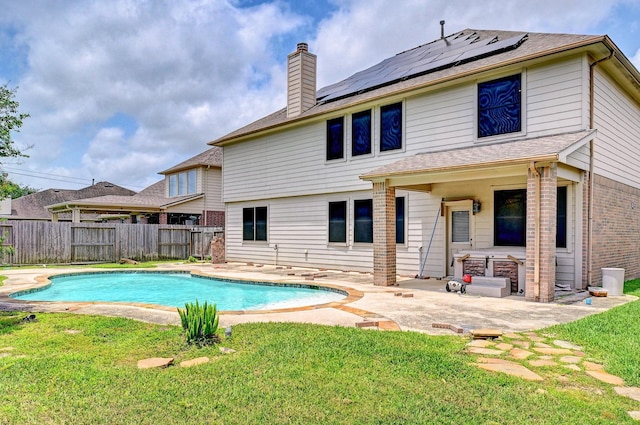 1752 Cypress Meadows Dr, Dickinson, TX 77539 - back of property with solar panels, a patio, a chimney, brick siding, and a shingled roof