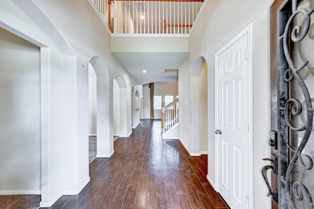1752 Cypress Meadows Dr, Dickinson, TX 77539 - entryway featuring arched walkways, baseboards, a towering ceiling, stairs, and wood finished floors