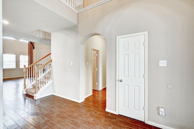1752 Cypress Meadows Dr, Dickinson, TX 77539 - unfurnished room featuring arched walkways, baseboards, wood finished floors, and stairs