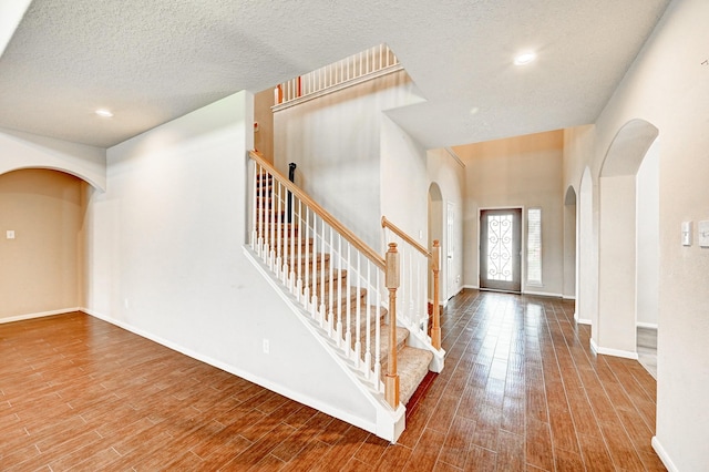 1752 Cypress Meadows Dr, Dickinson, TX 77539 - entryway with arched walkways, wood finished floors, a textured ceiling, baseboards, and recessed lighting