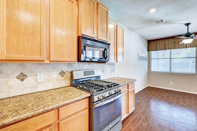 1752 Cypress Meadows Dr, Dickinson, TX 77539 - kitchen with stainless steel range with gas cooktop, black microwave, light brown cabinetry, decorative backsplash, and a textured ceiling