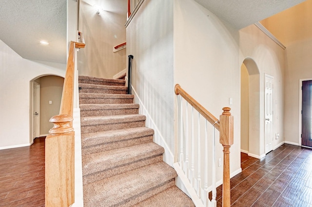 1752 Cypress Meadows Dr, Dickinson, TX 77539 - staircase with arched walkways, wood finished floors, a textured ceiling, and baseboards