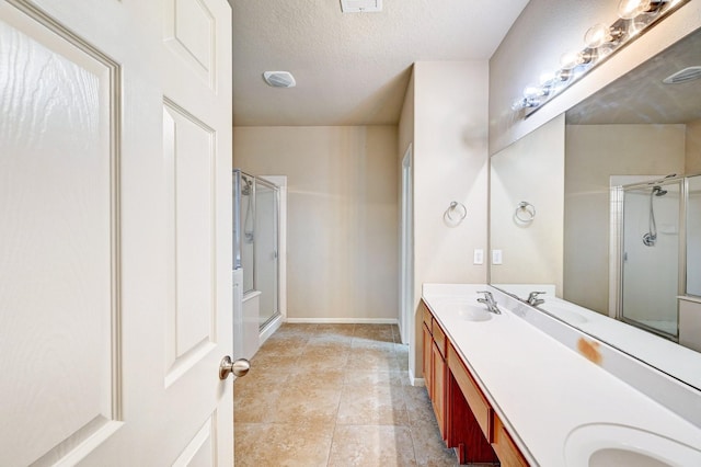1752 Cypress Meadows Dr, Dickinson, TX 77539 - full bathroom featuring a stall shower, double vanity, a textured ceiling, and baseboards