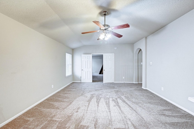 1752 Cypress Meadows Dr, Dickinson, TX 77539 - carpeted empty room featuring ceiling fan, a textured ceiling, baseboards, lofted ceiling, and arched walkways
