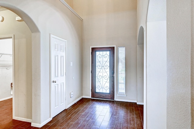 1752 Cypress Meadows Dr, Dickinson, TX 77539 - foyer featuring dark wood finished floors, arched walkways, baseboards, and a high ceiling