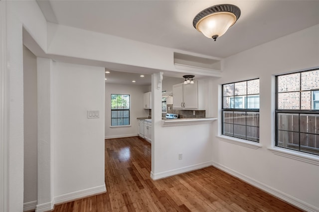 2308 Blodgett St, Houston, TX 77004 - kitchen featuring wood finished floors, white cabinets, baseboards, backsplash, and recessed lighting