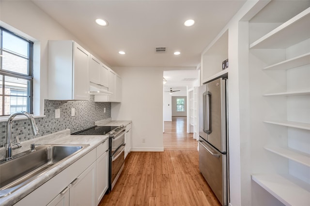 2308 Blodgett St, Houston, TX 77004 - kitchen featuring stainless steel appliances, a sink, under cabinet range hood, light wood-type flooring, and a ceiling fan