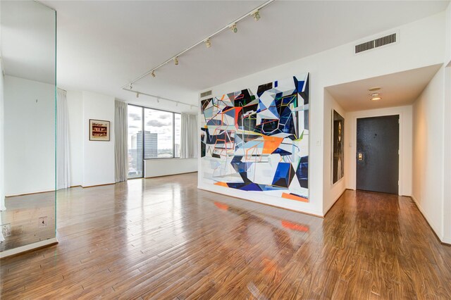 14 Greenway Plz Unit 19P, Houston, TX 77046 - unfurnished room featuring rail lighting and wood finished floors
