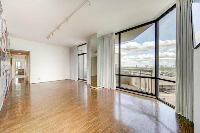14 Greenway Plz Unit 19P, Houston, TX 77046 - unfurnished room featuring expansive windows, wood finished floors, and track lighting