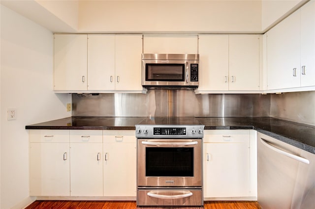 14 Greenway Plz Unit 19P, Houston, TX 77046 - kitchen featuring stainless steel appliances, backsplash, light wood finished floors, and dark countertops