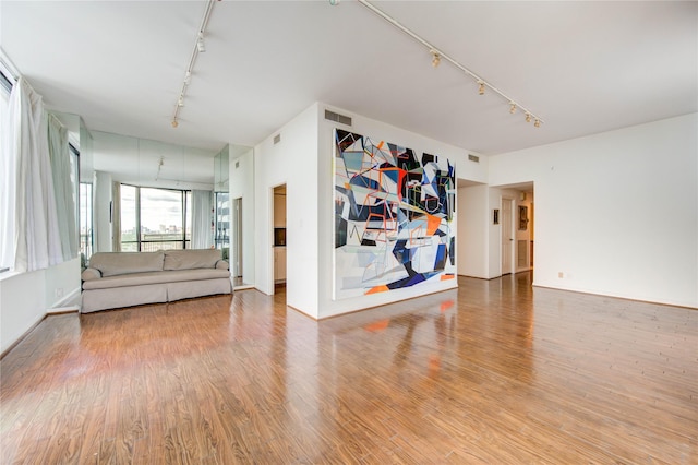 14 Greenway Plz Unit 19P, Houston, TX 77046 - unfurnished living room featuring track lighting and wood finished floors