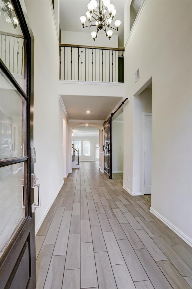 28618 Monarch Cliffs Dr, Fulshear, TX 77441 - entrance foyer featuring a chandelier, a high ceiling, arched walkways, baseboards, and wood finished floors
