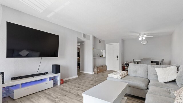 212 Plaza Verde Dr Unit F-22, Houston, TX 77038 - living area featuring wood finished floors, a ceiling fan, and baseboards