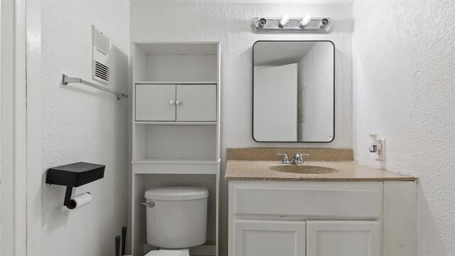 212 Plaza Verde Dr Unit F-22, Houston, TX 77038 - bathroom featuring toilet, vanity, and a textured wall