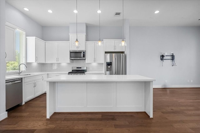 2607 Mcilhenny St, Houston, TX 77004 - kitchen with appliances with stainless steel finishes, a sink, a center island, backsplash, and white cabinetry