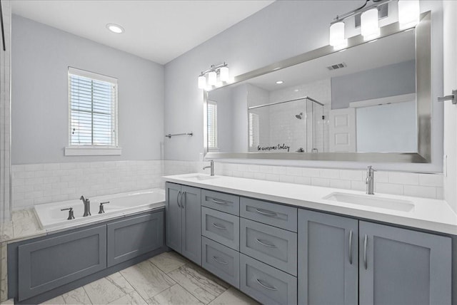 2607 Mcilhenny St, Houston, TX 77004 - bathroom with a shower stall, marble finish floors, double vanity, a bath, and recessed lighting