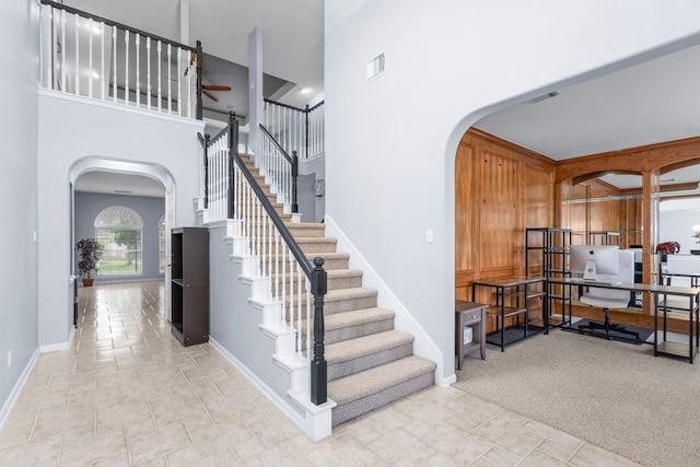 3815 Griffin Ln, Missouri City, TX 77459 - staircase featuring arched walkways, a towering ceiling, baseboards, and ceiling fan