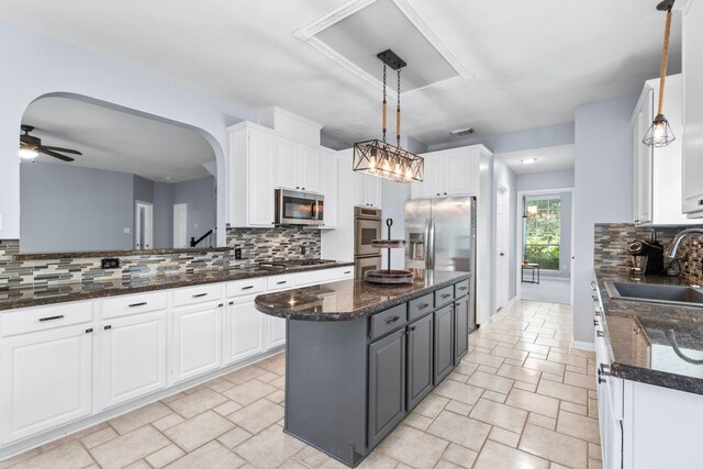 3815 Griffin Ln, Missouri City, TX 77459 - kitchen featuring stainless steel appliances, a sink, white cabinets, a kitchen island, and backsplash