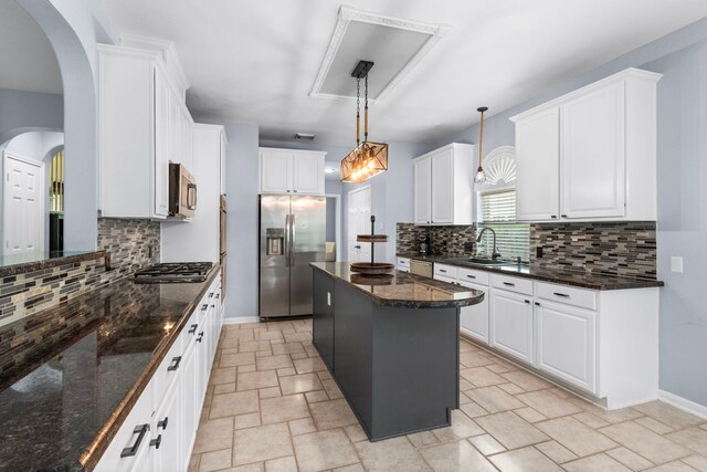 3815 Griffin Ln, Missouri City, TX 77459 - kitchen featuring appliances with stainless steel finishes, stone tile floors, tasteful backsplash, and white cabinets