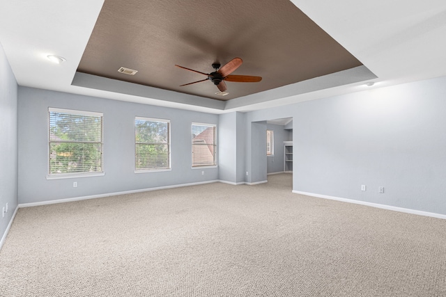 3815 Griffin Ln, Missouri City, TX 77459 - unfurnished room featuring a tray ceiling, baseboards, ceiling fan, carpet flooring, and a textured ceiling