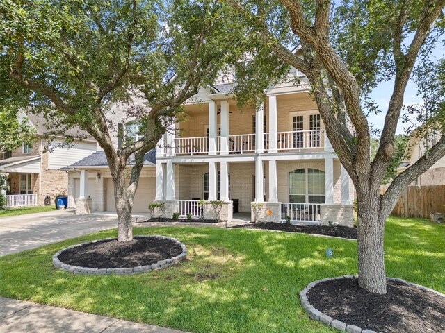 1012 Walnut Pointe, League City, TX 77573 - neoclassical / greek revival house featuring a porch, brick siding, a balcony, driveway, and a garage