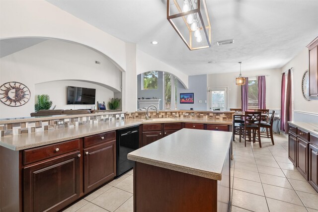 1012 Walnut Pointe, League City, TX 77573 - kitchen featuring black dishwasher, a sink, a kitchen island, light tile patterned floors, and light countertops