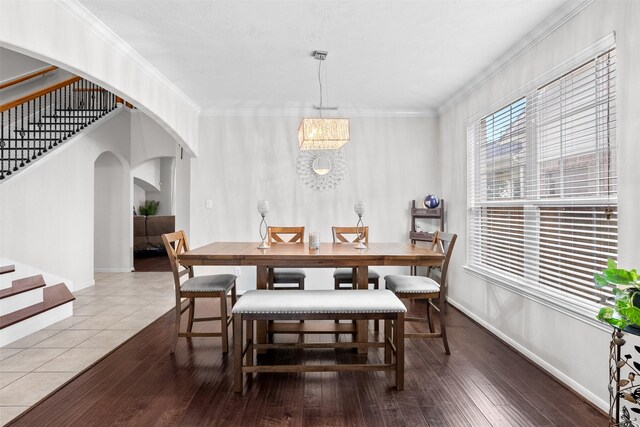 1012 Walnut Pointe, League City, TX 77573 - dining room with stairs, arched walkways, baseboards, and crown molding