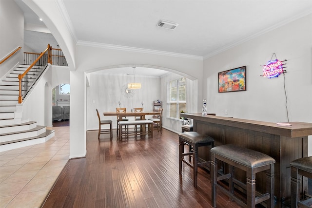 1012 Walnut Pointe, League City, TX 77573 - indoor dry bar featuring arched walkways, stairs, crown molding, hardwood / wood-style flooring, and baseboards