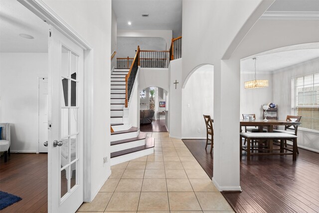 1012 Walnut Pointe, League City, TX 77573 - tiled foyer with arched walkways, stairway, baseboards, a chandelier, and crown molding