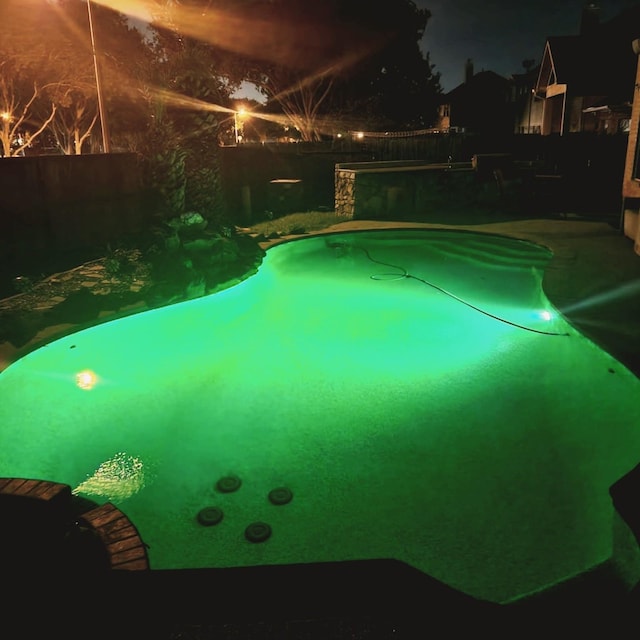 1012 Walnut Pointe, League City, TX 77573 - pool at night featuring a fenced backyard