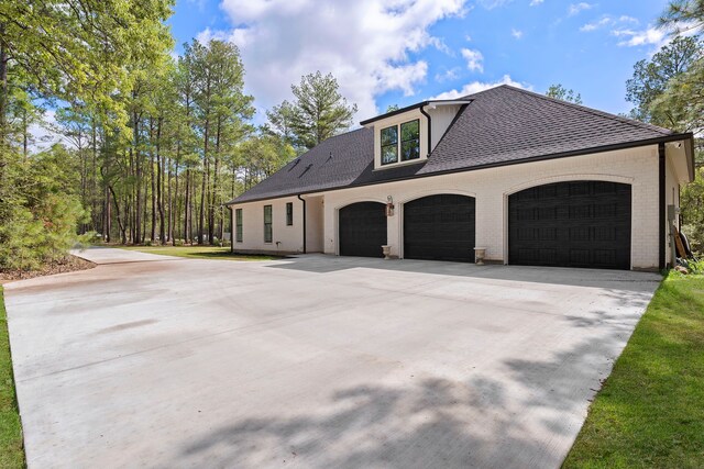 567 Lonestar Rd, Huntsville, TX 77340 - view of property exterior with concrete driveway, brick siding, a garage, and a shingled roof