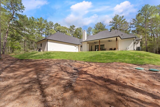 567 Lonestar Rd, Huntsville, TX 77340 - rear view of property featuring a ceiling fan, a chimney, a yard, and central AC