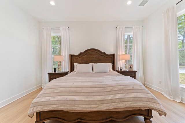 567 Lonestar Rd, Huntsville, TX 77340 - bedroom with multiple windows, recessed lighting, light wood-style floors, and baseboards