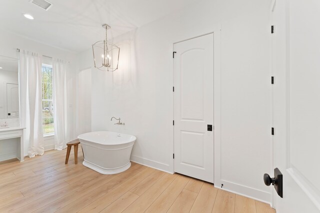 567 Lonestar Rd, Huntsville, TX 77340 - bathroom featuring a soaking tub, wood finished floors, vanity, a chandelier, and recessed lighting