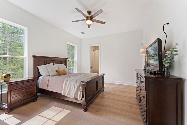 567 Lonestar Rd, Huntsville, TX 77340 - bedroom with light wood-style flooring, multiple windows, baseboards, and ensuite bathroom