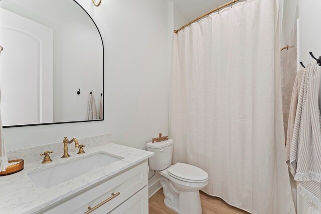 567 Lonestar Rd, Huntsville, TX 77340 - bathroom featuring toilet, vanity, curtained shower, and wood finished floors