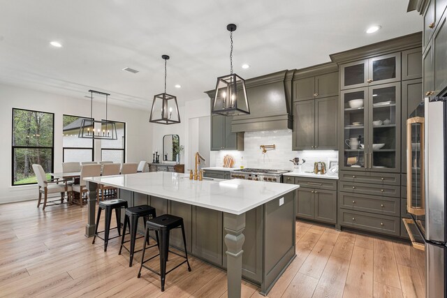 567 Lonestar Rd, Huntsville, TX 77340 - kitchen featuring freestanding refrigerator, a sink, decorative backsplash, custom exhaust hood, and a kitchen breakfast bar