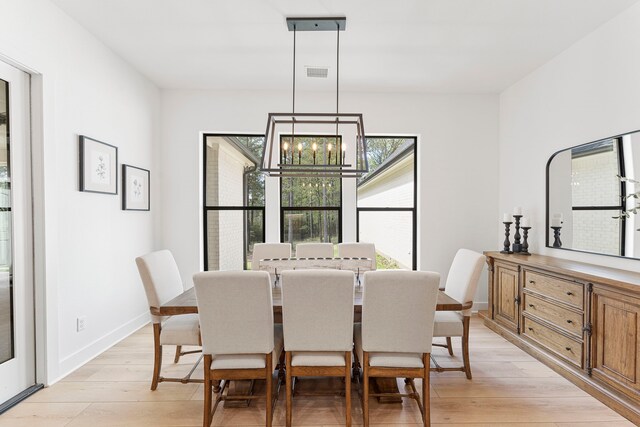 567 Lonestar Rd, Huntsville, TX 77340 - dining room featuring a chandelier, light wood-style floors, and baseboards