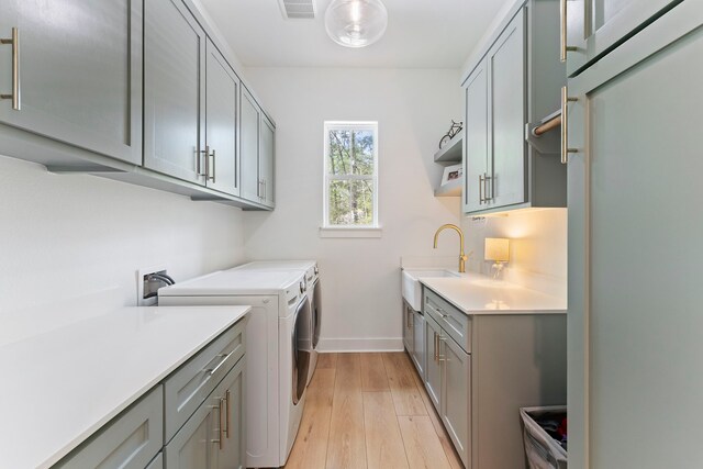 567 Lonestar Rd, Huntsville, TX 77340 - laundry room with washer and dryer, cabinet space, baseboards, and light wood-style floors