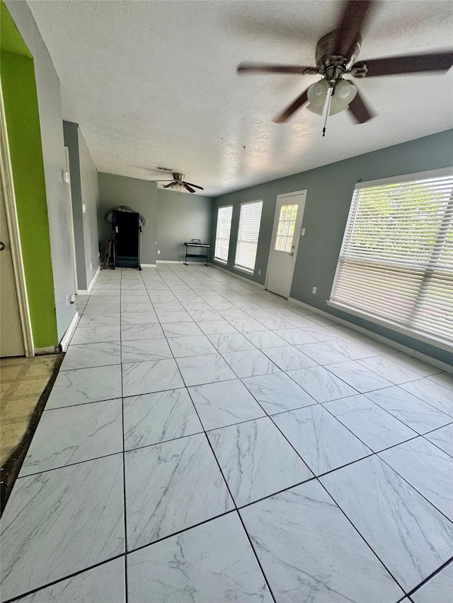 4631 Mi Castillo Ct, Houston, TX 77045 - unfurnished living room featuring light marble finish flooring, ceiling fan, a textured ceiling, and baseboards