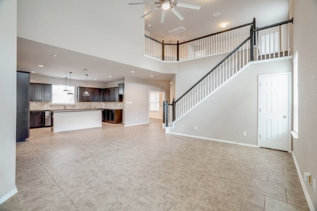 6763 Indian Ldg, San Antonio, TX 78253 - unfurnished living room featuring a towering ceiling, a ceiling fan, baseboards, light tile patterned floors, and stairs