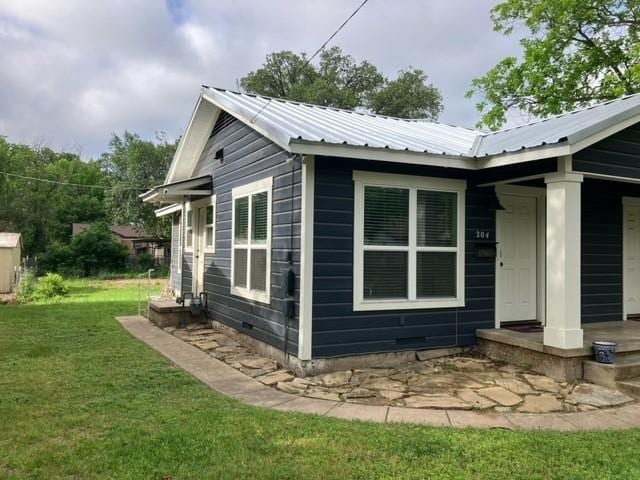 204 E Dry St, San Saba, TX 76877 - view of property exterior with a lawn and metal roof