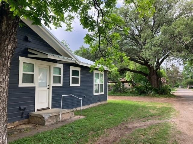 204 E Dry St, San Saba, TX 76877 - view of property exterior with a yard, metal roof, and crawl space