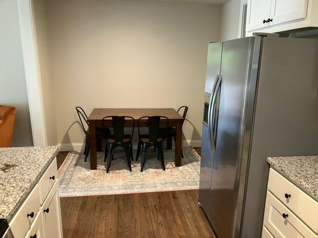 204 E Dry St, San Saba, TX 76877 - dining space featuring dark wood-type flooring and baseboards